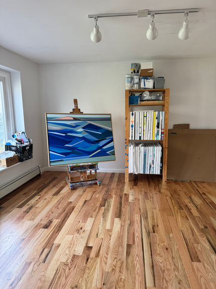 Artist Shilo Ratner Studio  interior with wooden wall, bookshelf, and abstract painting.